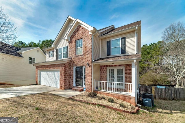 view of front of house with a garage, central AC, a front yard, and covered porch