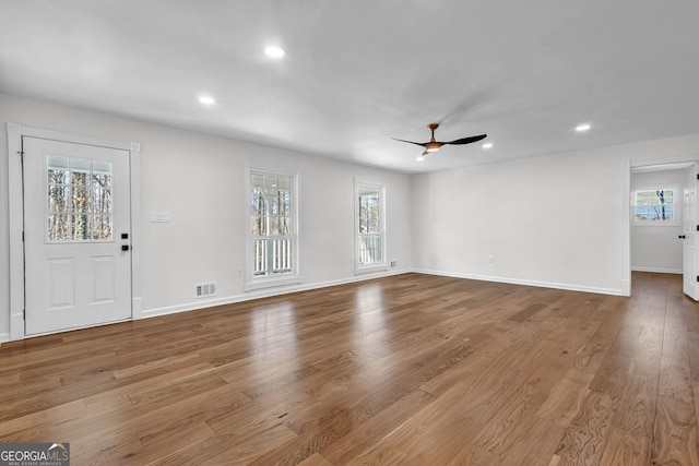 unfurnished living room with ceiling fan, hardwood / wood-style flooring, and a healthy amount of sunlight