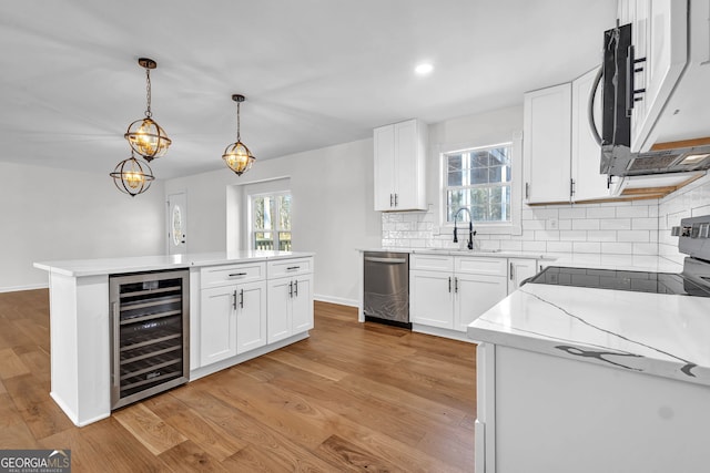 kitchen with white cabinetry, dishwasher, sink, wine cooler, and hanging light fixtures