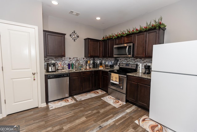 kitchen with stainless steel appliances, sink, and dark brown cabinetry