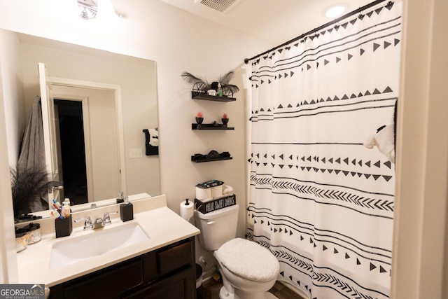 bathroom featuring vanity, curtained shower, and toilet