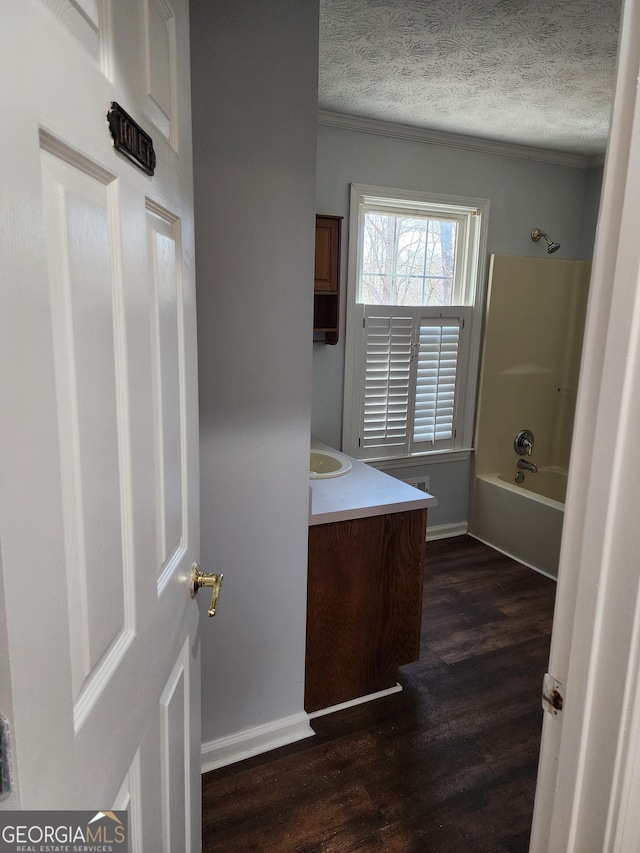 bathroom with bathing tub / shower combination, wood-type flooring, vanity, and a textured ceiling