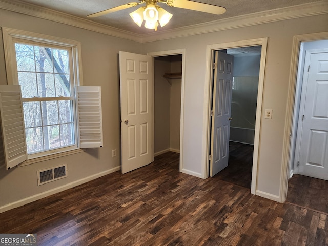 unfurnished bedroom featuring dark wood-type flooring, ornamental molding, a closet, and ceiling fan