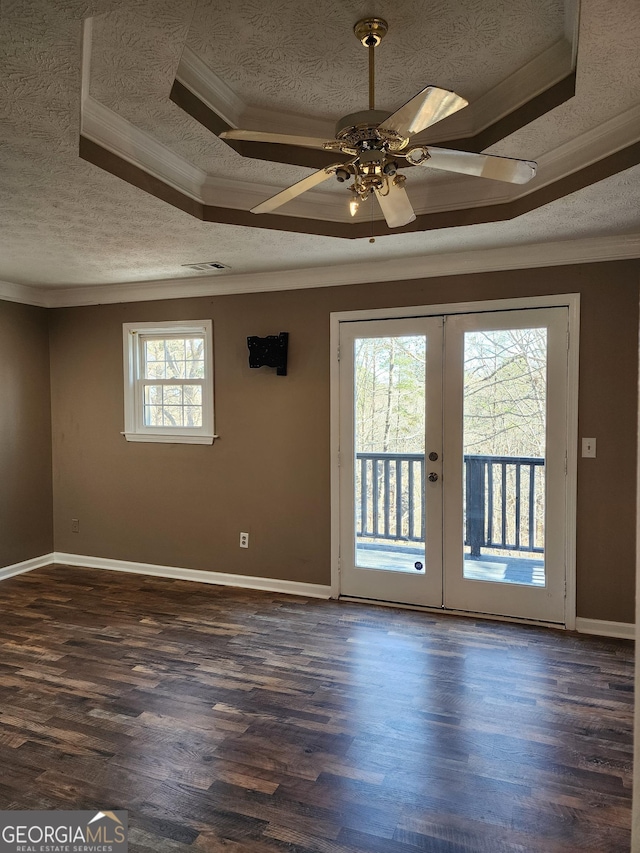 spare room with ornamental molding, dark hardwood / wood-style floors, a textured ceiling, and french doors