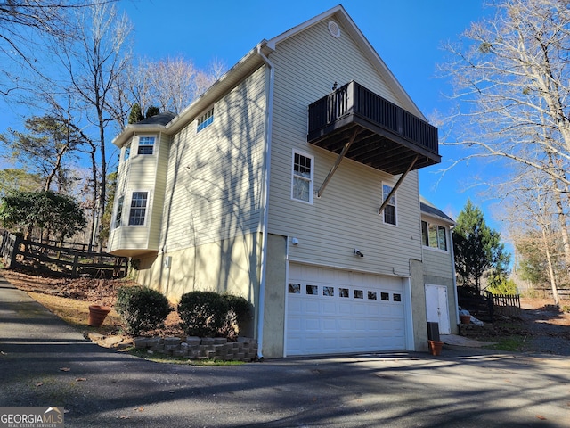 view of side of property with a garage and a balcony