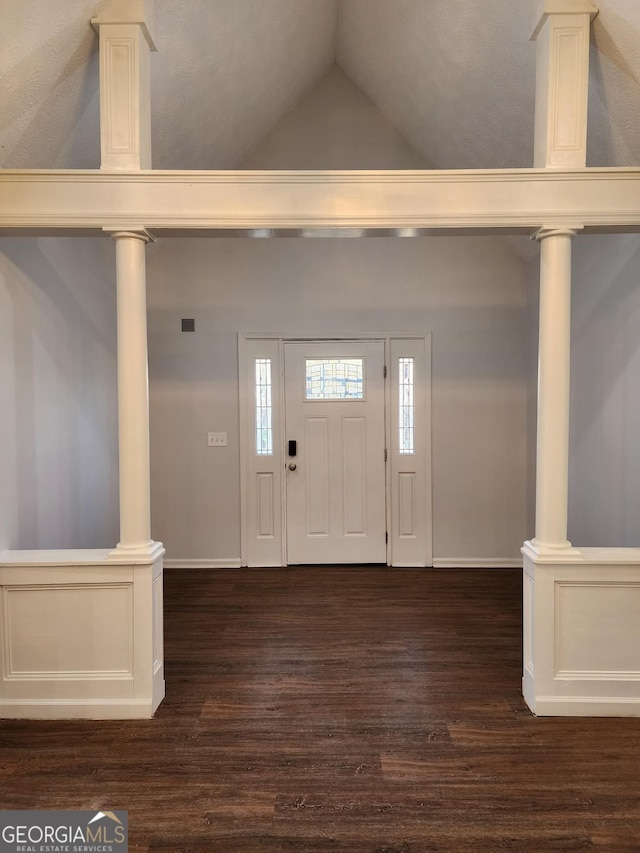 foyer with decorative columns, lofted ceiling, and dark hardwood / wood-style floors