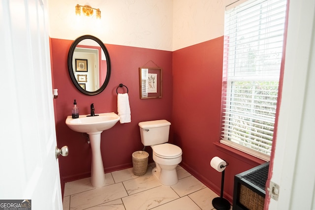 bathroom with heating unit, plenty of natural light, and toilet