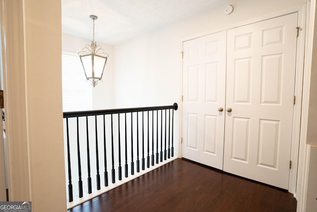 hall featuring dark hardwood / wood-style floors and a notable chandelier