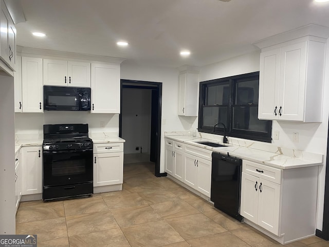 kitchen featuring white cabinets, light stone countertops, sink, and black appliances