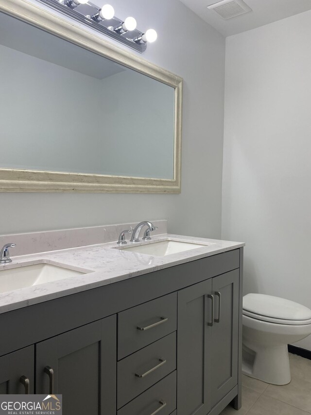 bathroom featuring tile patterned flooring, vanity, and toilet