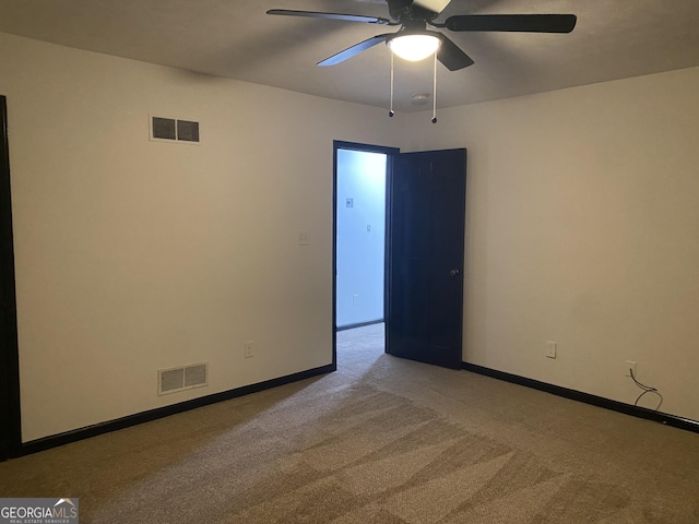 carpeted spare room featuring ceiling fan