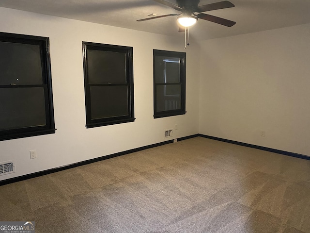 spare room with ceiling fan and light carpet