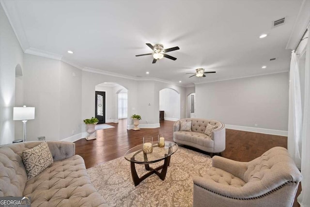 living room with crown molding, ceiling fan, and dark hardwood / wood-style flooring