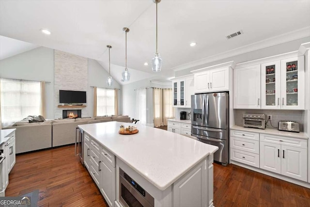 kitchen with a kitchen island, white cabinetry, lofted ceiling, dark hardwood / wood-style flooring, and stainless steel appliances