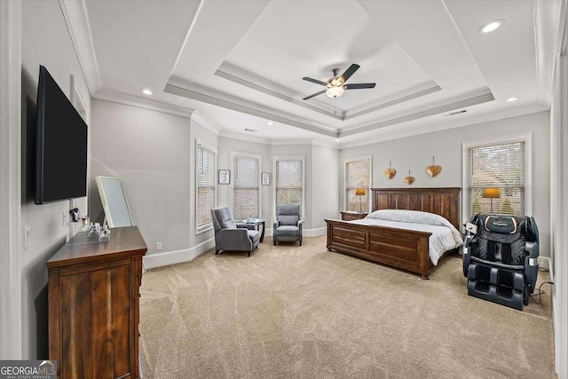 bedroom featuring ornamental molding, light colored carpet, ceiling fan, and a tray ceiling