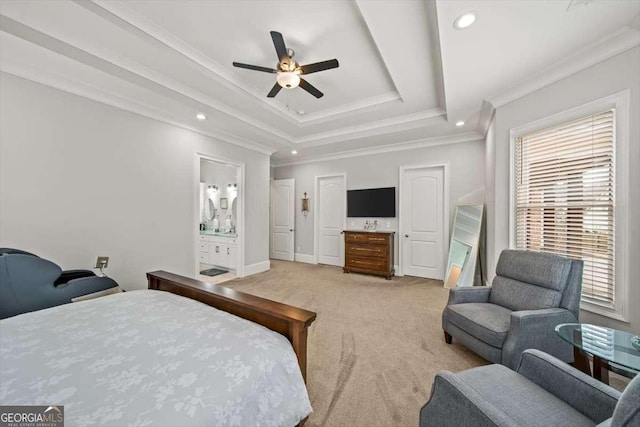 carpeted bedroom featuring a raised ceiling, crown molding, ensuite bathroom, and ceiling fan