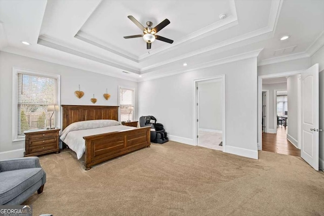 carpeted bedroom featuring a tray ceiling, ornamental molding, and ceiling fan