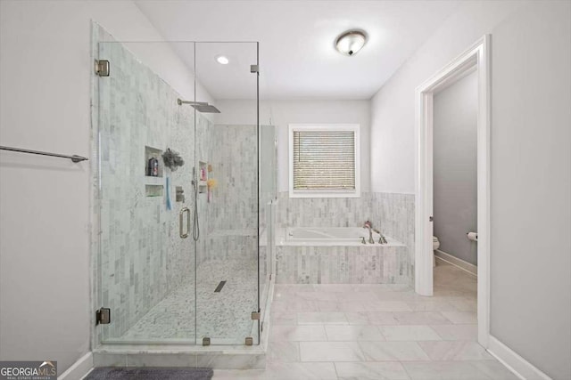 bathroom featuring toilet and shower with separate bathtub