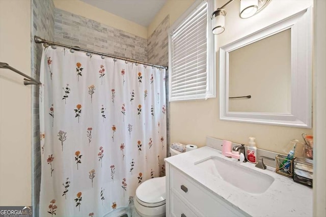 bathroom featuring vanity, curtained shower, and toilet