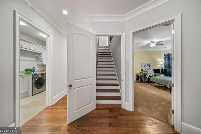 stairs featuring washer / clothes dryer, crown molding, hardwood / wood-style flooring, and ceiling fan