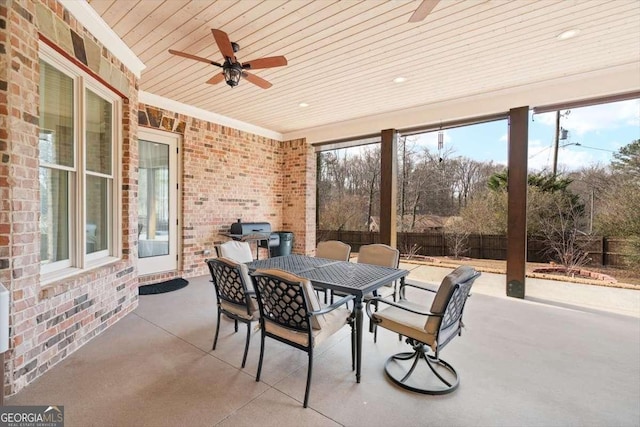 sunroom featuring ceiling fan and wood ceiling