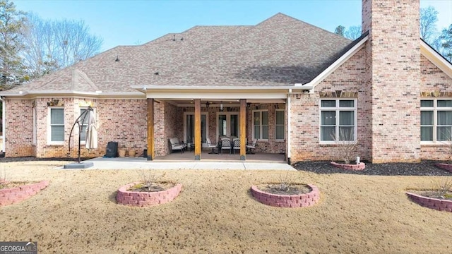 rear view of property with a lawn and a patio area