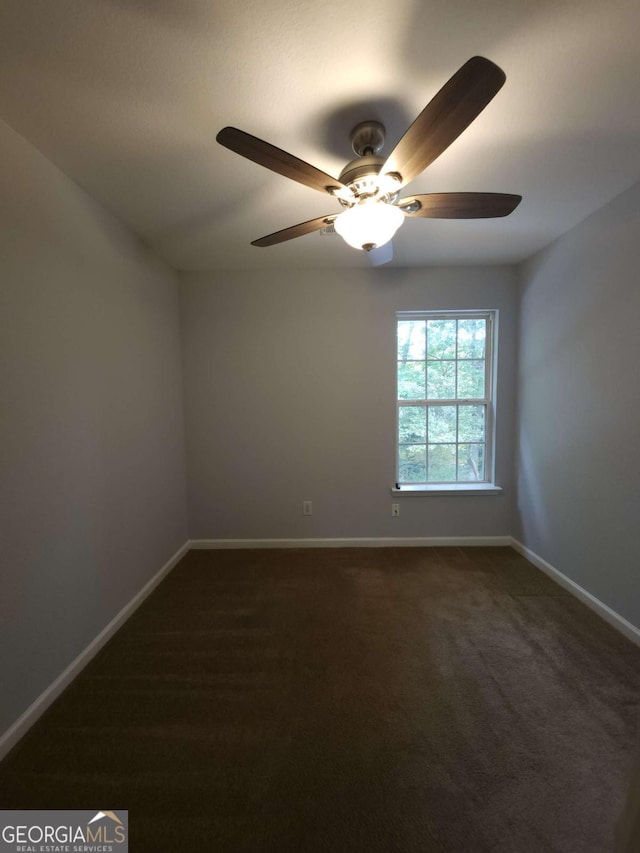 unfurnished room featuring ceiling fan and dark carpet