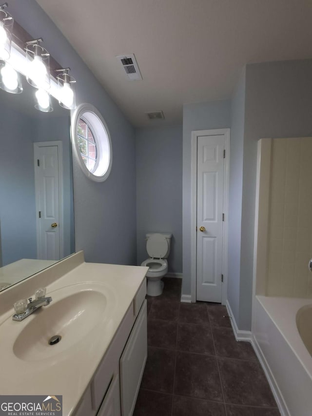 bathroom with vanity, tile patterned floors, a tub, and toilet