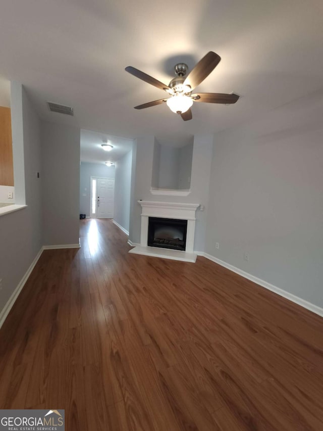 unfurnished living room featuring hardwood / wood-style flooring and ceiling fan