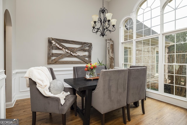 dining area featuring a healthy amount of sunlight, hardwood / wood-style floors, and a chandelier