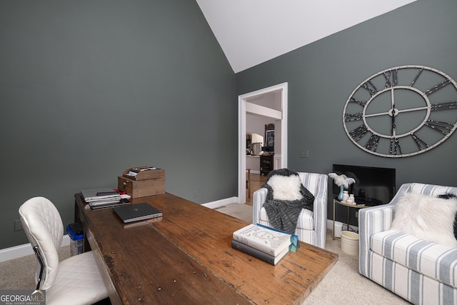 home office with lofted ceiling and light colored carpet