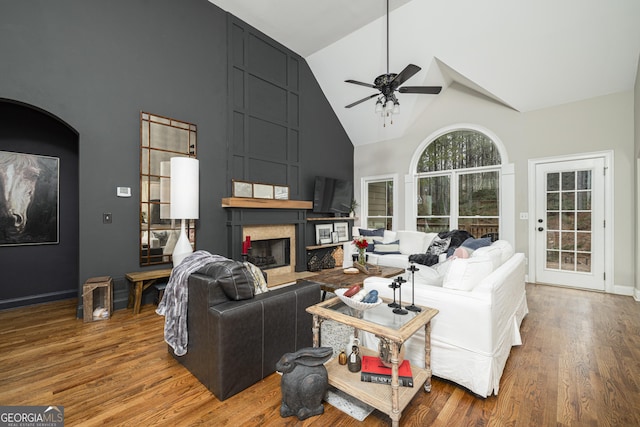 living room featuring ceiling fan, high vaulted ceiling, and hardwood / wood-style floors