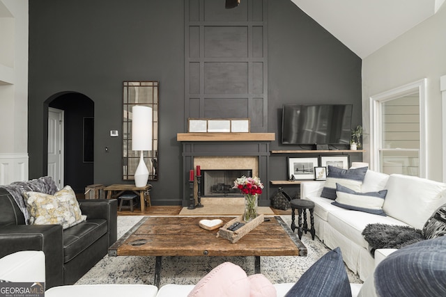 living room with high vaulted ceiling and a large fireplace