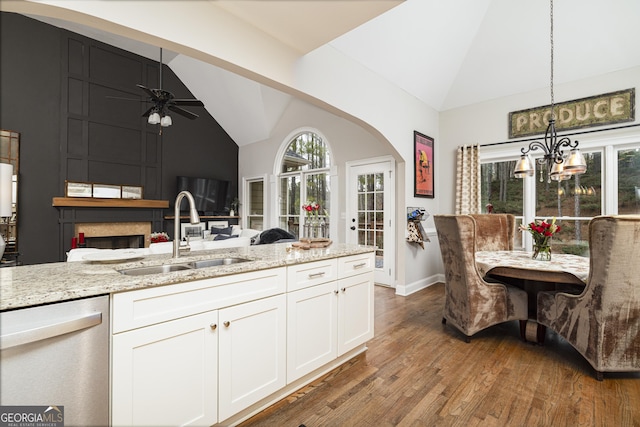 kitchen featuring sink, hanging light fixtures, dishwasher, light stone countertops, and white cabinets