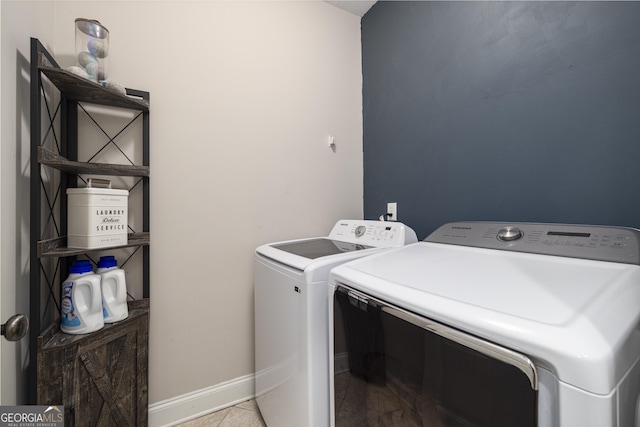 clothes washing area featuring tile patterned floors and washer and dryer