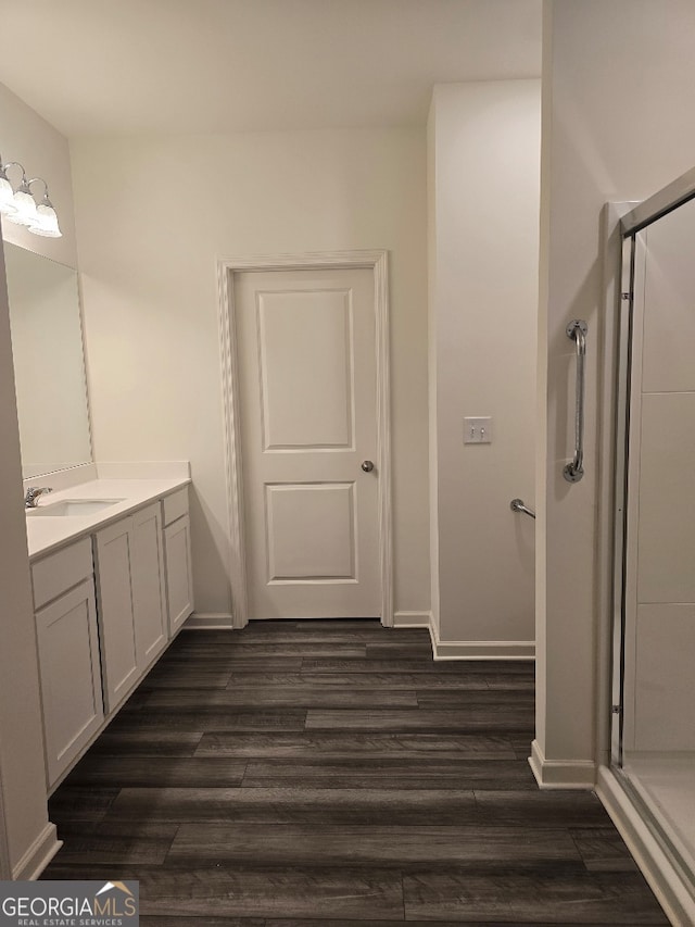 bathroom with vanity, an enclosed shower, and hardwood / wood-style flooring