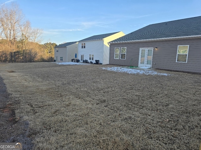 rear view of house featuring a lawn and french doors