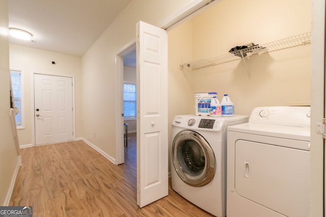 laundry room with washer and dryer and light wood-type flooring