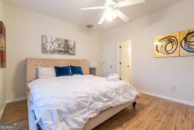 bedroom featuring visible vents, ceiling fan, baseboards, and wood finished floors