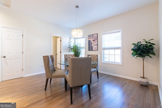 dining area featuring hardwood / wood-style flooring and an inviting chandelier