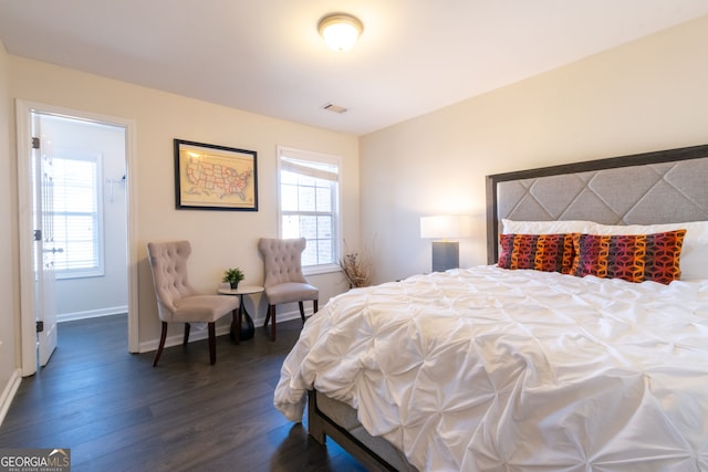 bedroom with dark wood finished floors, visible vents, and baseboards