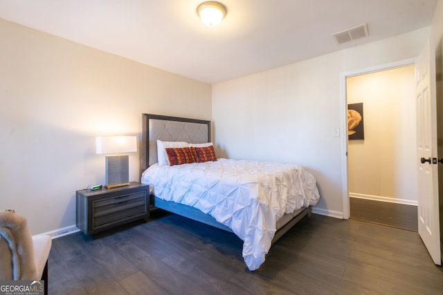 bedroom featuring wood finished floors, visible vents, and baseboards