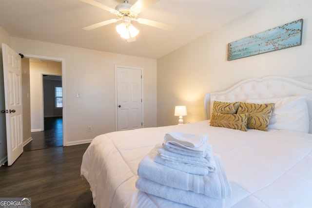 bedroom featuring dark wood finished floors, attic access, baseboards, and ceiling fan