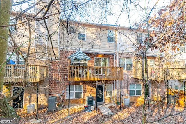 rear view of property with brick siding and central AC unit