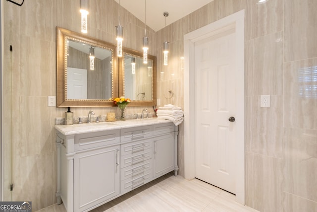 full bathroom with a sink, tile walls, and double vanity