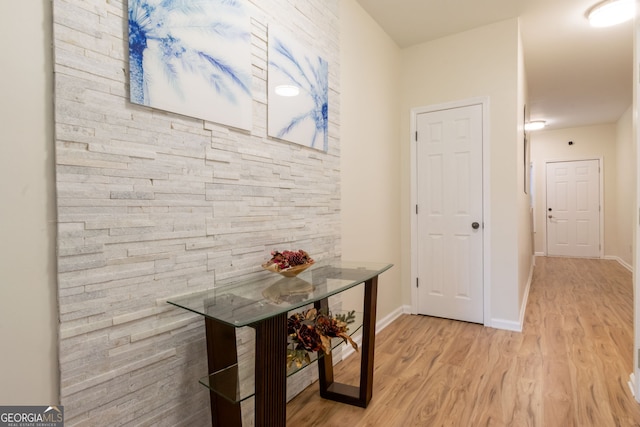 hallway featuring light wood-style floors and baseboards