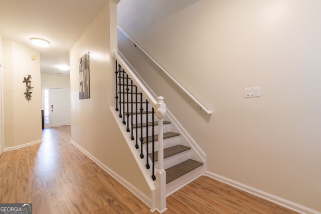 staircase with wood finished floors and baseboards