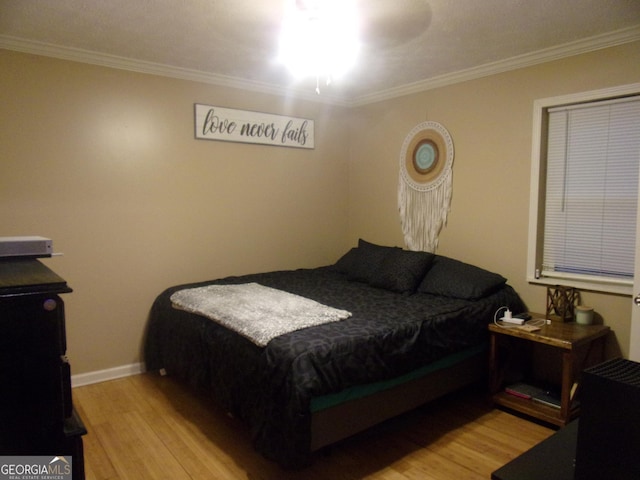 bedroom featuring ornamental molding and light hardwood / wood-style floors