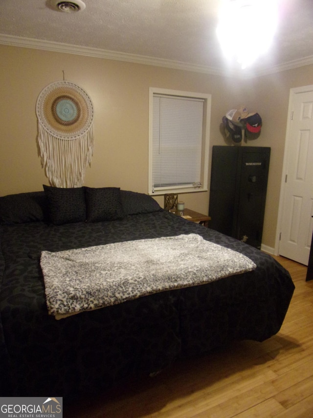 bedroom with wood-type flooring and ornamental molding