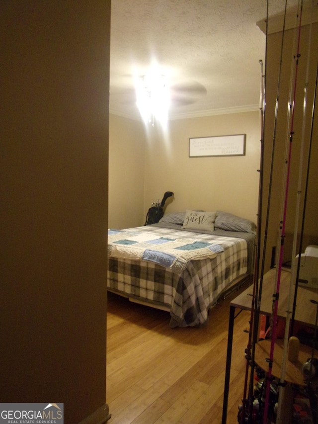 bedroom featuring ornamental molding and hardwood / wood-style floors